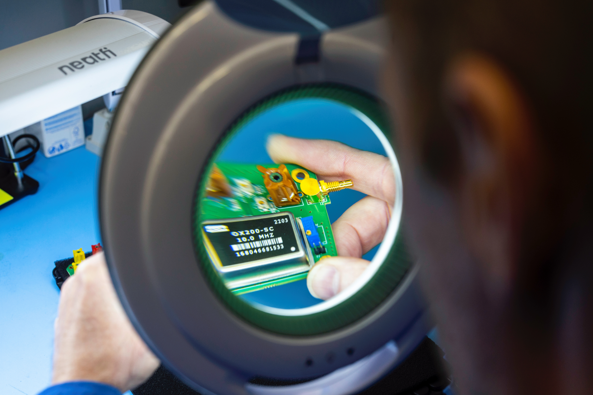 MPE-2024-Inspecting-9 Technician performing visual inspection as part of MPE Electronics’ pcb assembly service, ensuring component accuracy and quality compliance.