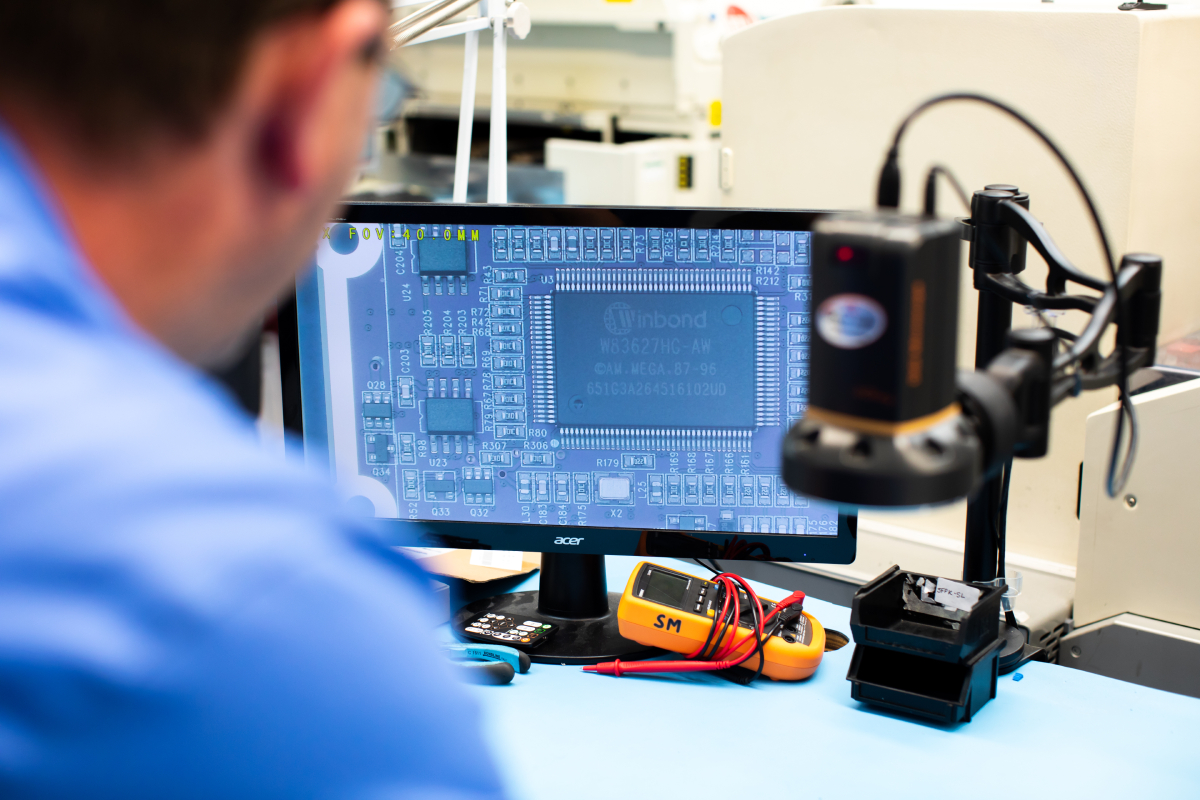 pcb-inspection-product-quality-reliability A member of the MPE production team inspects a PCB assembly